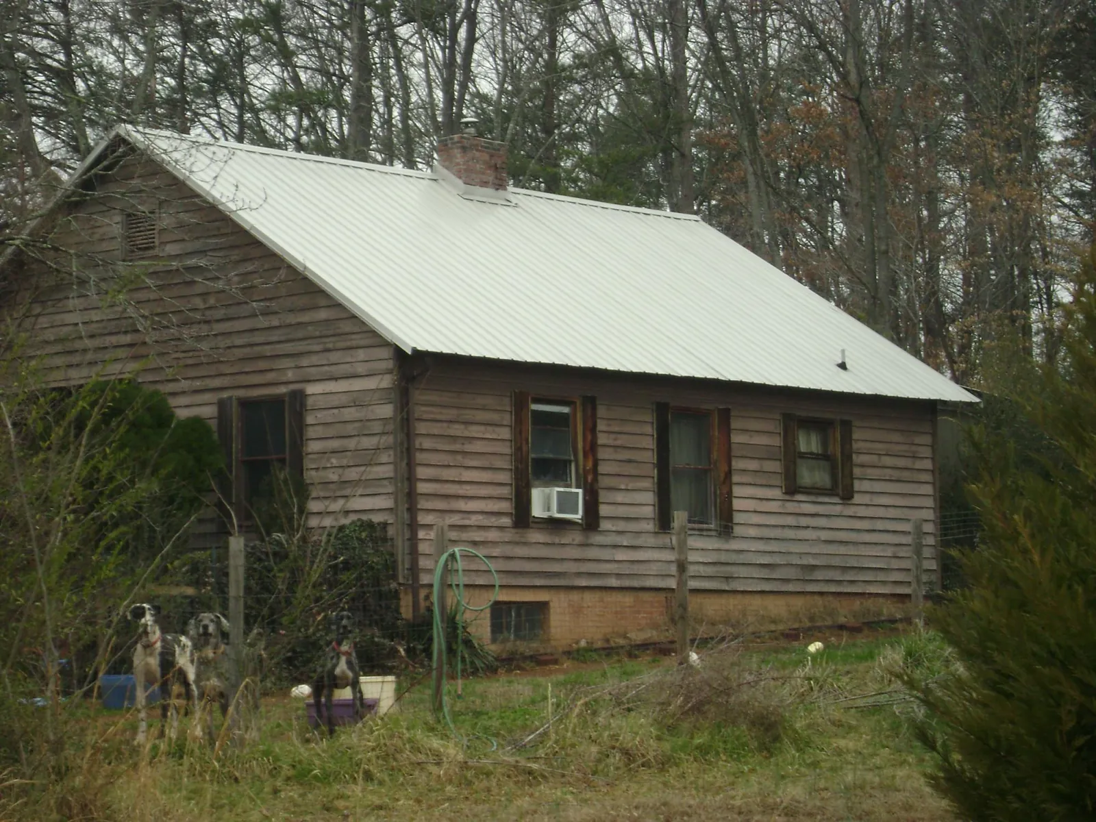 White metal roof on an old wood sided farmhouse, from a Metal Roof Installation job in Holcomb